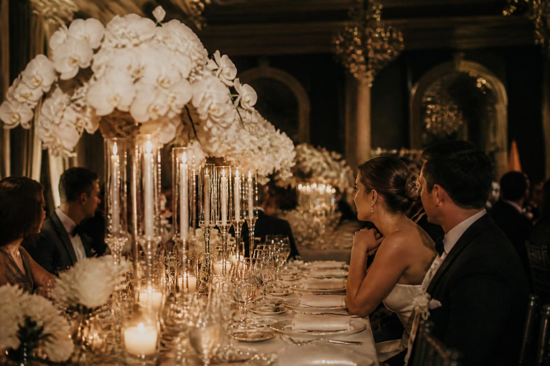 Mesa de jantar de casamento iluminada por velas em salão elegante